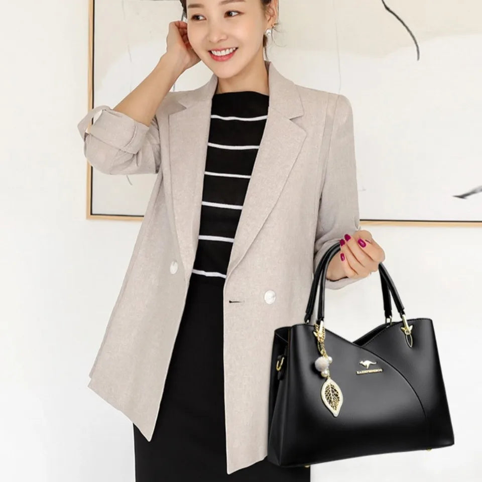 Elegancka czarna torebka na ramię z stylowymi zawieszkami